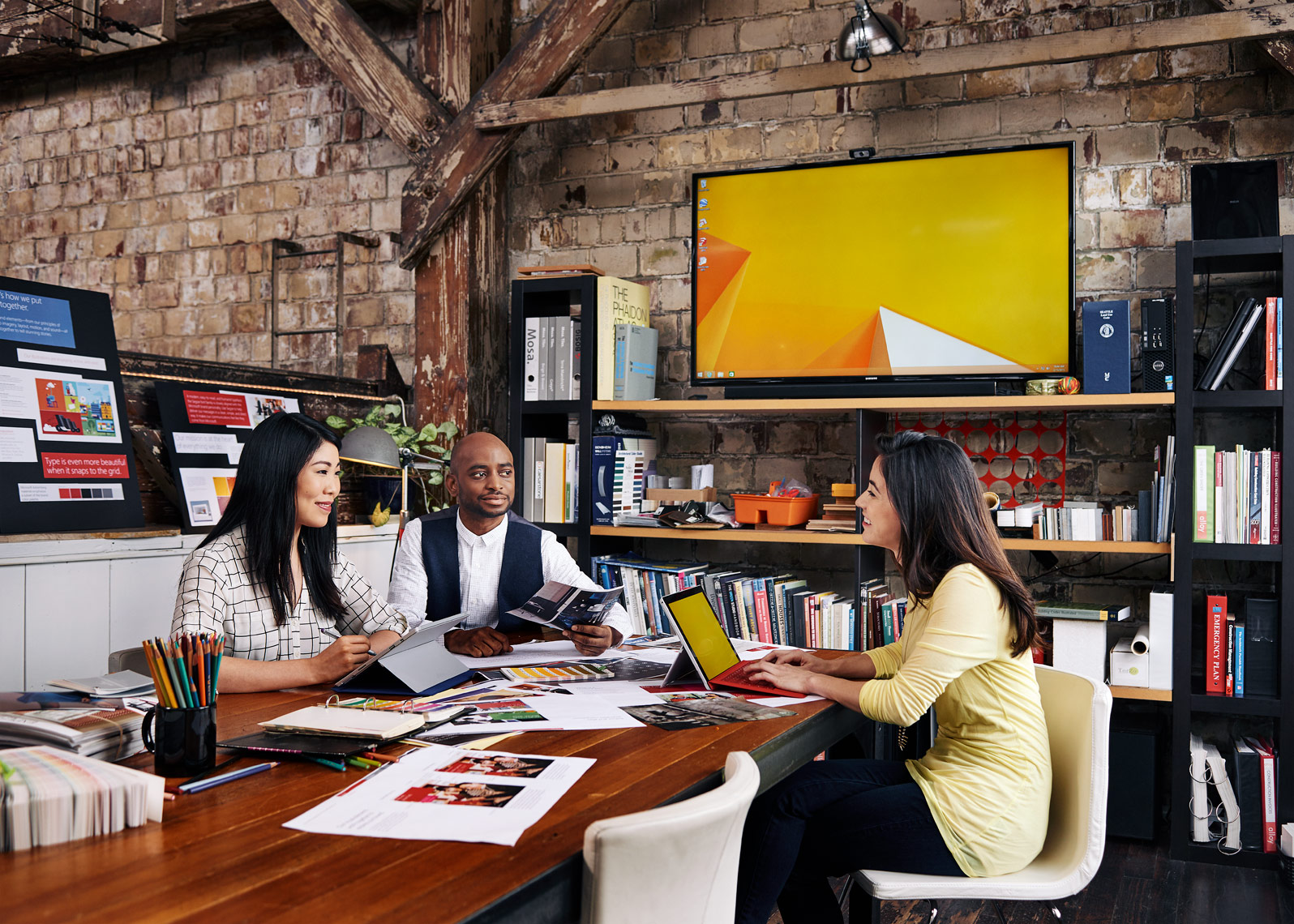 employees gather around a group conference table in an urban office