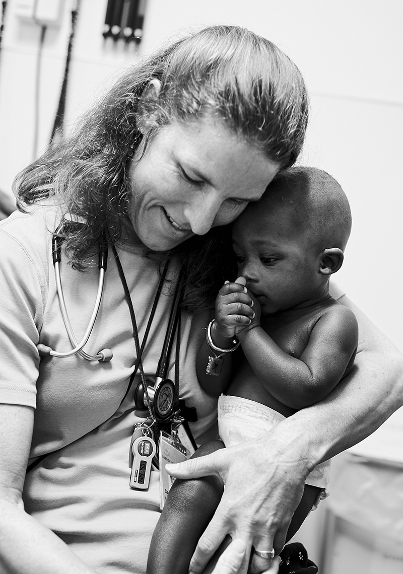Doctor giving love to baby at community health clinic