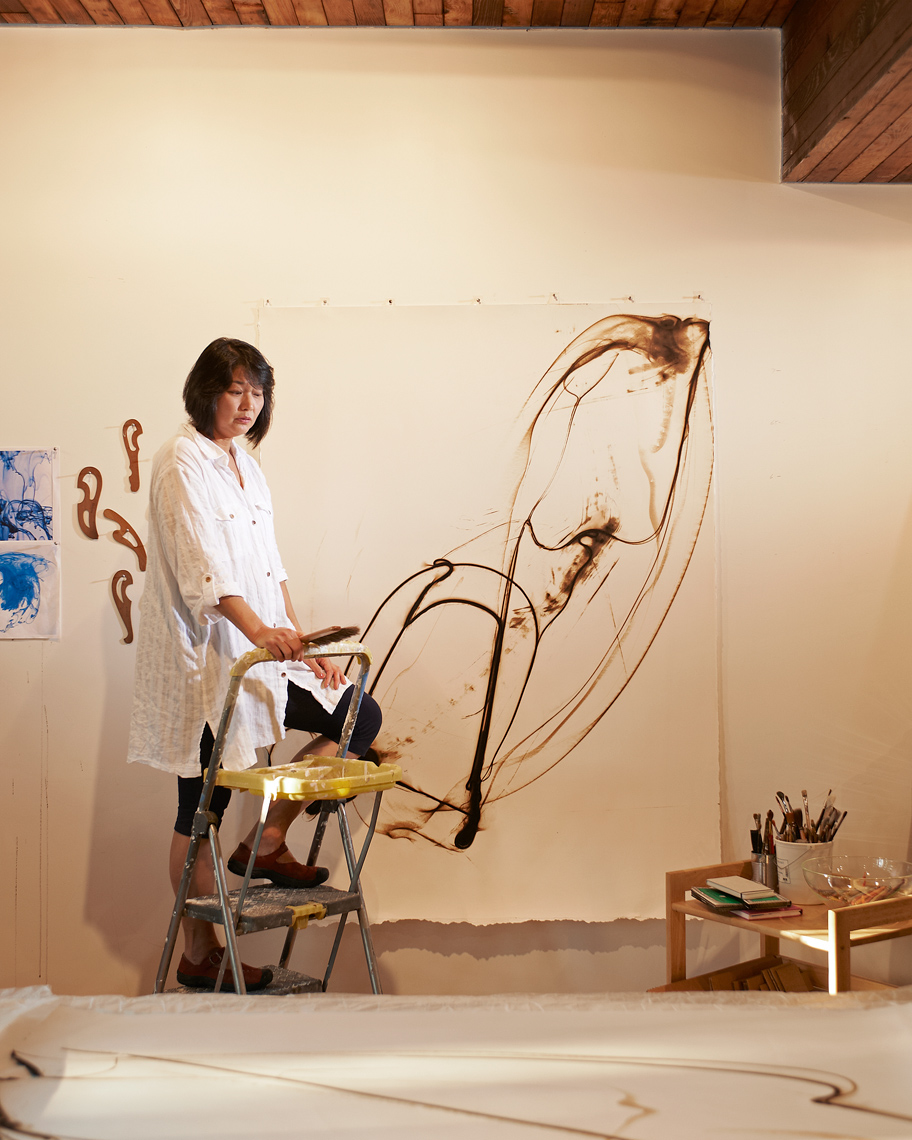 Artist, EtsukoIchikawa works on her latest work as Amos Morgan takes her portrait