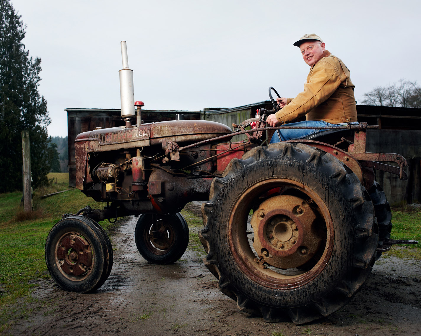 Farmer sits atop old fashioned tractor 